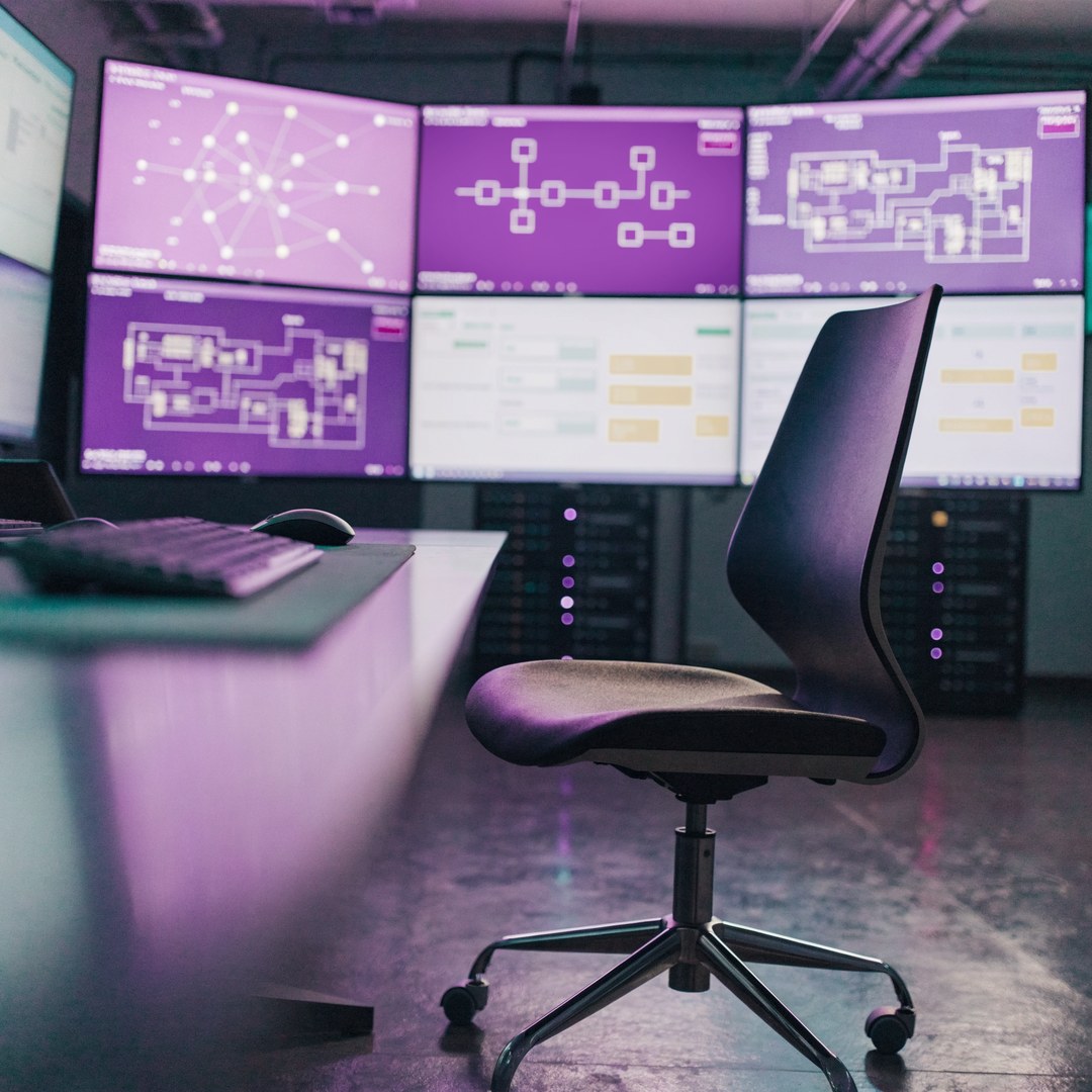 KI-generierte Szene: leere Leitstelle bei Nacht mit Monitorwand, Netzwerk- und Gebäudeplänen
